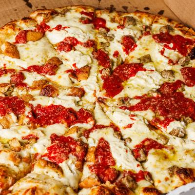 Pizza topped with melted cheese, sausage, and red sauce.