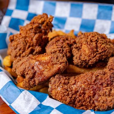 Buffalo wings served over fries.