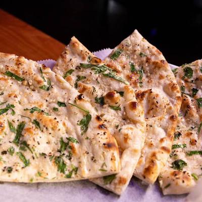 Garlic naan sprinkled with herbs.