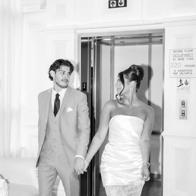 Couple holding hands by the elevator.