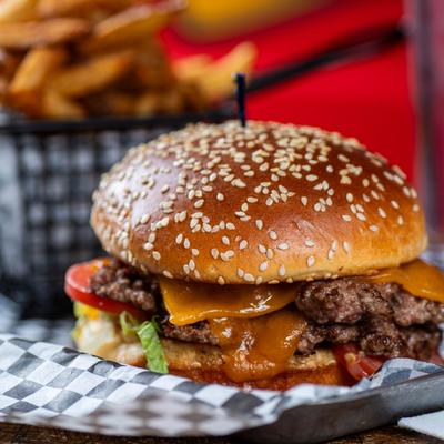 Selective focus on The Sheriff's Smash Burger with fries in background.