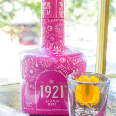 A bottle of tequila cream and a glass.