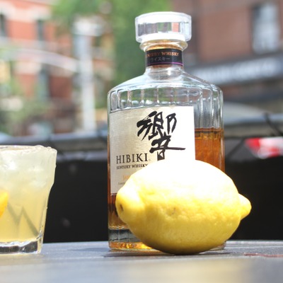 Yellow cocktail, a lemon and a bottle of suntory whiskey