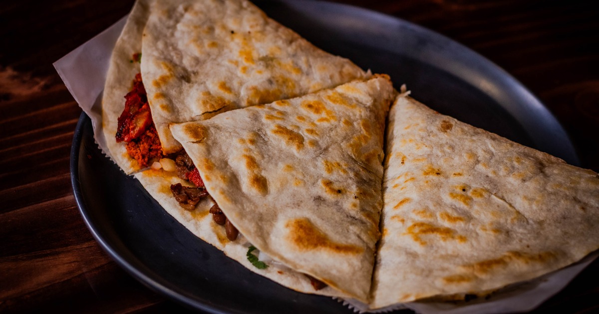 Quesadilla with melted cheese, Mexican sausage, guacamole and sour cream