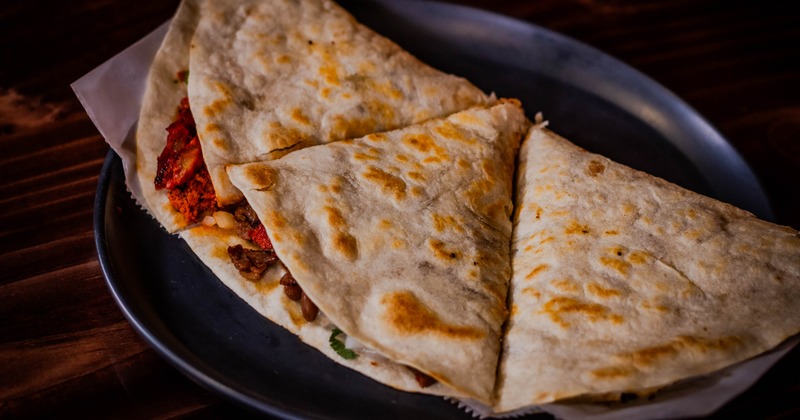 Quesadilla with melted cheese, Mexican sausage, guacamole and sour cream