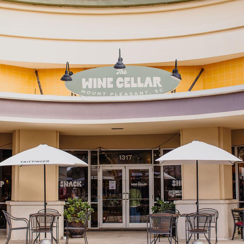 Exterior, storefont with entrance, signage and outdoor patio with umbrellas.