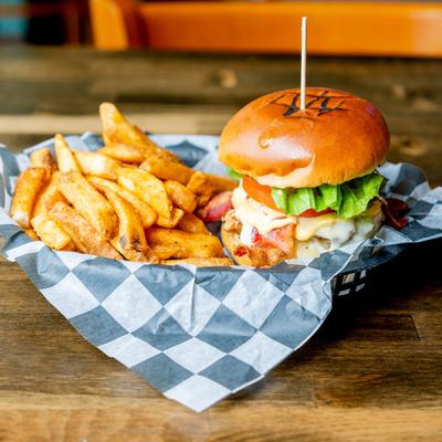 Cheeseburger with bacon, lettuce, and tomatoes served with fries.