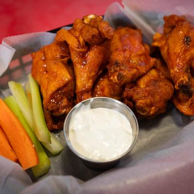 Buffalo wings, served with celery, carrots, and ranch dressing.