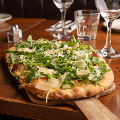 Pizza topped with arugula and shaved Parmesan.