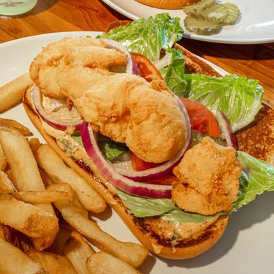Breaded Shrimp Po Boy with lettuce, tomatoes, pickles, onions and fries.