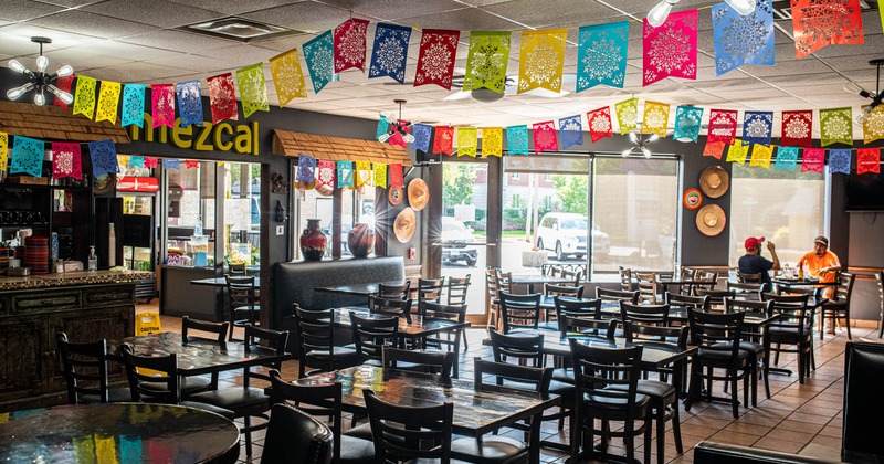 Interior, dining tables and seating, Mexican street banners on the ceiling