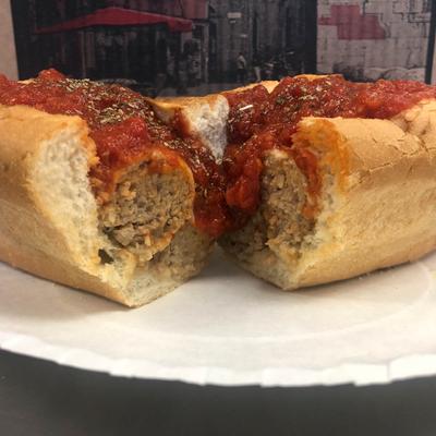 Meatball sub sandwich with tomato sauce.