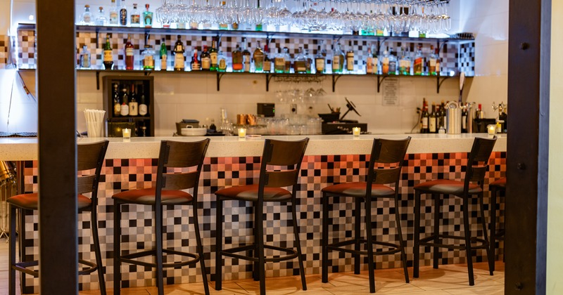 Bar, chairs, drink rack behind