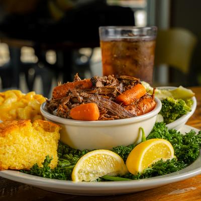 Braised Pot Roast with steamed broccoli, mac and cheese, cornbread, lemon garnish.