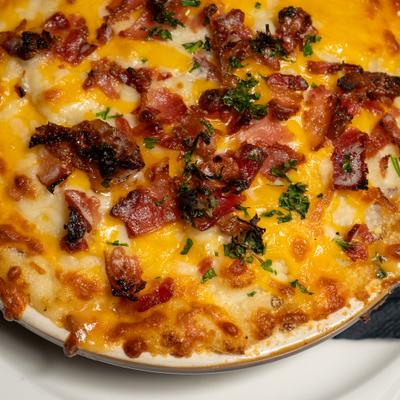 Loaded Sheppards Pie topped with cheese and bacon, close-up.