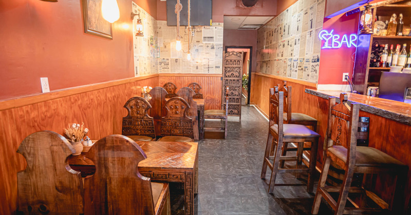 Interior, traditionally designed wooden tables and chairs for guests and the bar