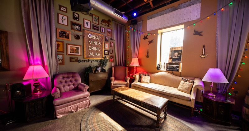 Seating area with sofa, armchairs and coffee table, pictures on the wall