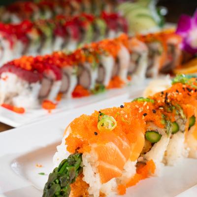 Close up of lined up assorted sushi roll plates.