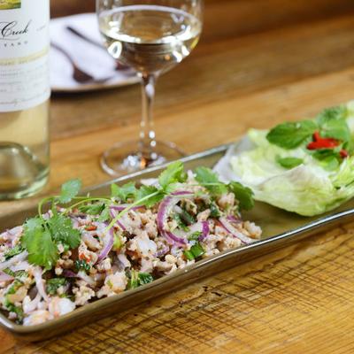 Naked Shrimp served with a glass of white wine.