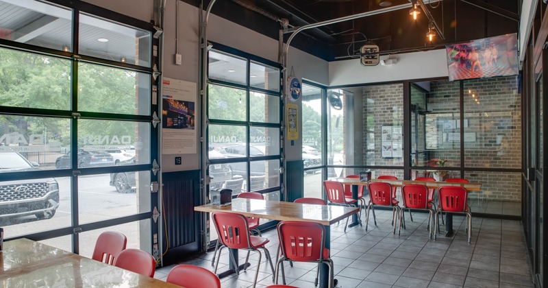 Interior, dining area, wooden top tables for eight and four people, shop window