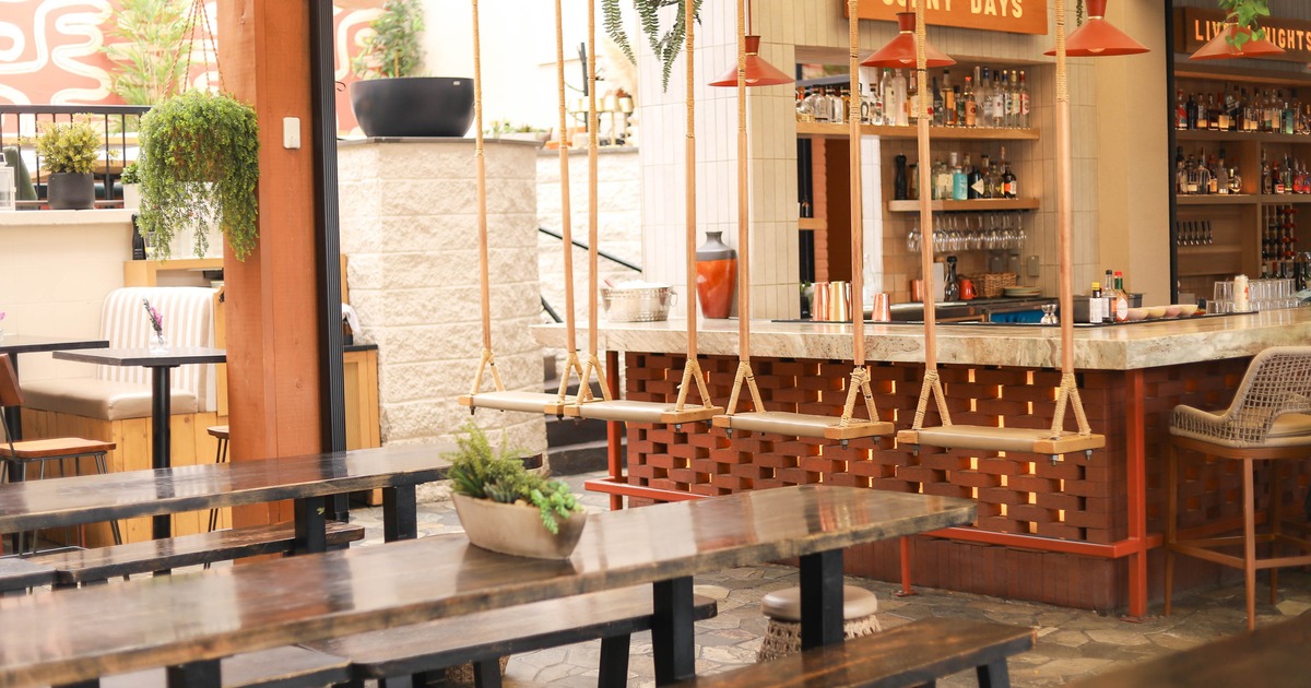 Seating and bar are, tables with benches, marble top bar with stools and swing seats