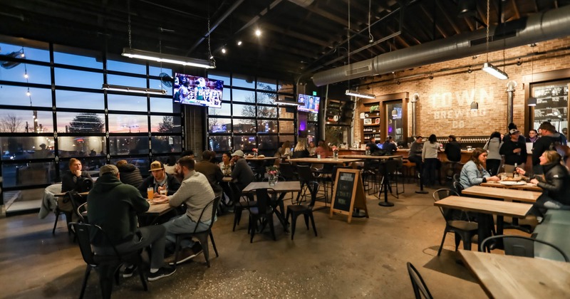 Interior, industrial, wide view, guests enjoying food and drinks
