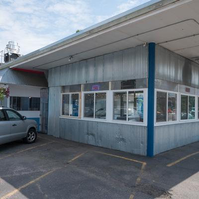 The exterior of the restaurant and the parking in front.