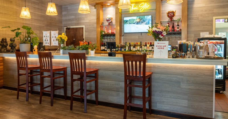 Cozy restaurant bar with wooden chairs and warm pendant lighting