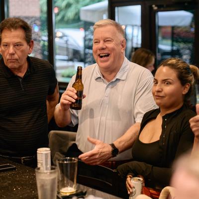 People socializing around a bar with drinks.