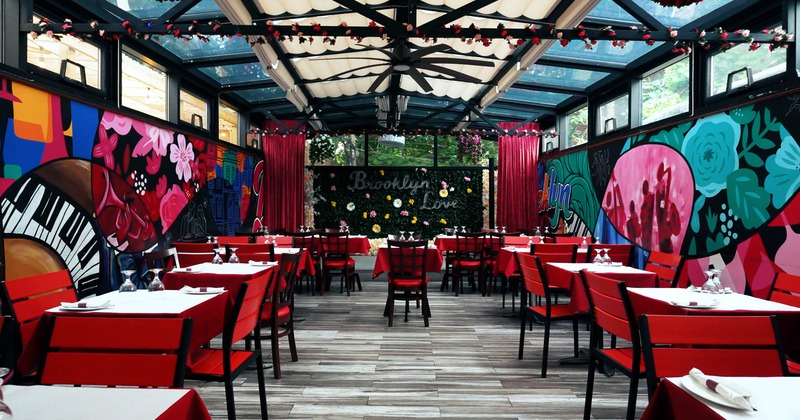Colorful restaurant interior with murals,  tables, and  a wall decorated with flowers