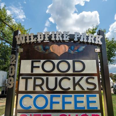 Wildfire Park sign advertising food trucks and coffee.