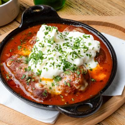 Sausage and Meatballs in tomato saauce, topped with cheese and herbs.