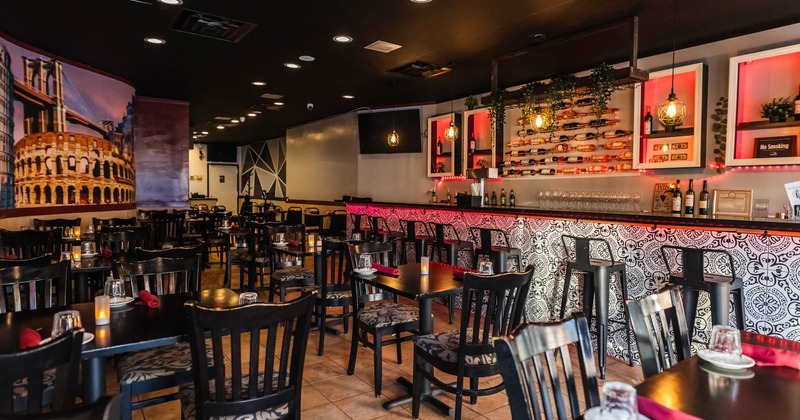 Interior, wide open view of a seating area with a bar on the right
