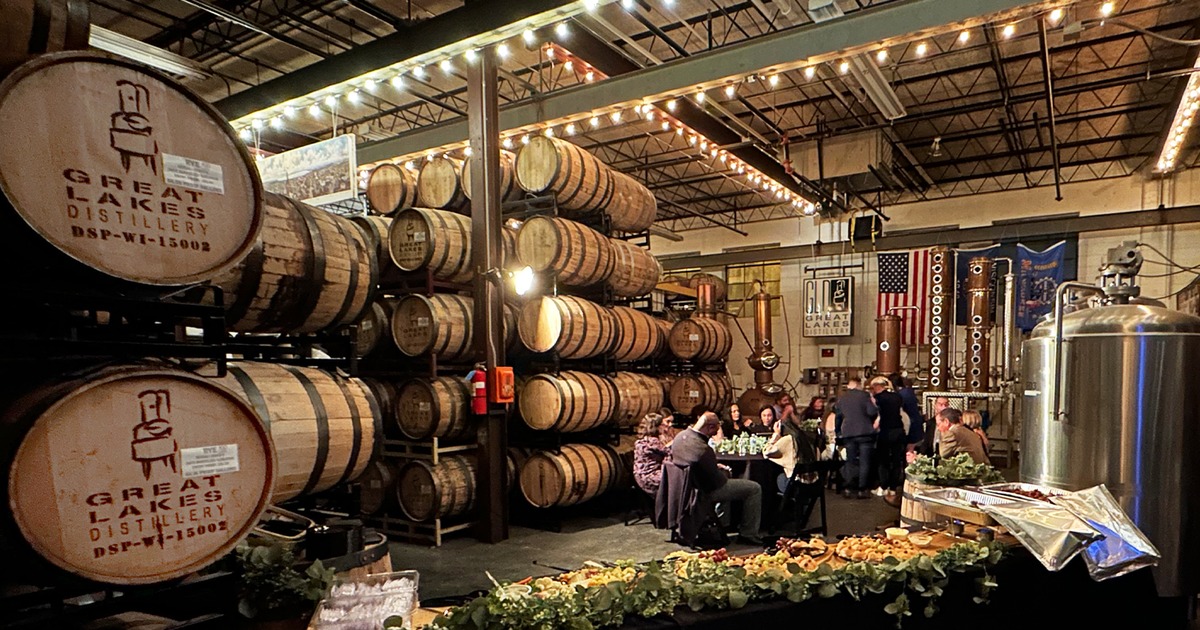 People sitting at tables in front of barrel racks