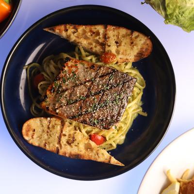 Salmon pesto linguine served with toasted garlic bread.