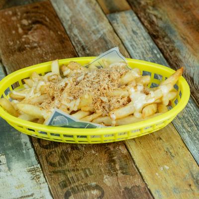 Crab meat fries topped with sauce in a yellow basket.