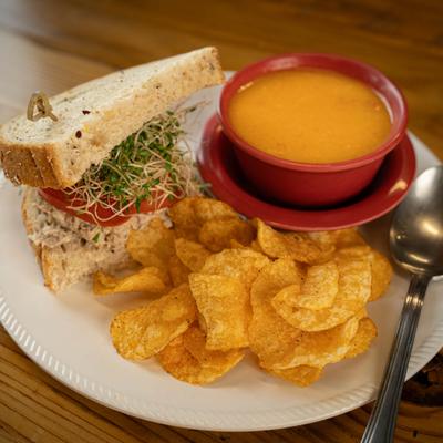 Soup & 1/2 Tuna Salad Sandwich with potato chips on the plate.