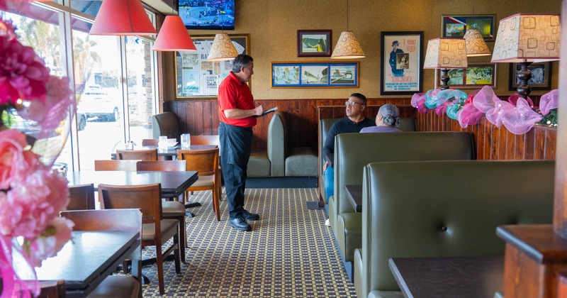 Diner area, booths, the waiter receives the order