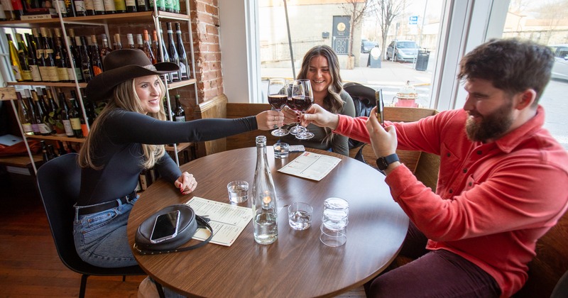 Interior, round table, guests drink wine, toasting