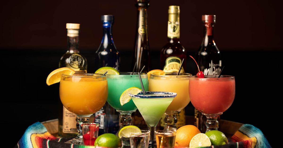 Bottled drinks, cocktails and shots arranged on the table