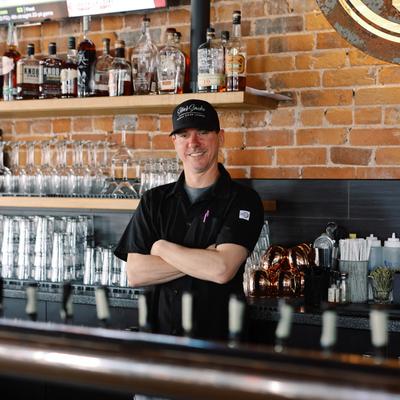 Bartender posing behind the bar.