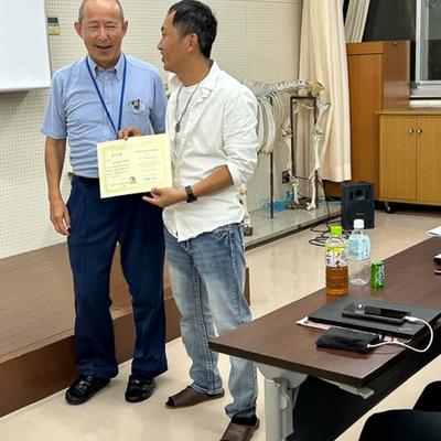 Two people posing with a certificate.