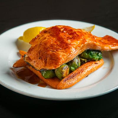 Grilled salmon served atop Brussels sprouts and plantains.