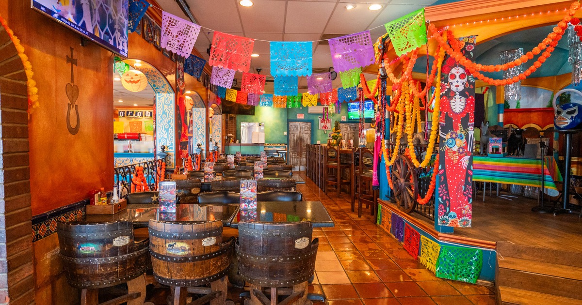Interior of a Mexican-themed restaurant with colorful papel picado banners and marigold garlands