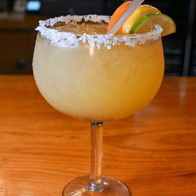 Margarita served in a salt-rimmed glass, garnished with citrus slices.