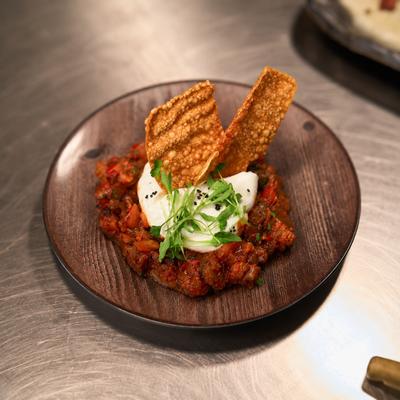 Burrata salad: creamy burrata served with tomato sofrito & plantain fricassee..