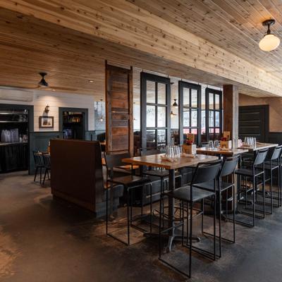 Interior with a mix of high-top tables with bar stools and a booth seating area.