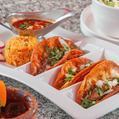 Three quesabirria tacos served with Mexican rice and consomme.