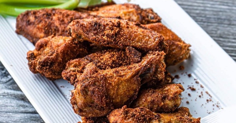 Platter of seasoned chicken wings served with celery sticks