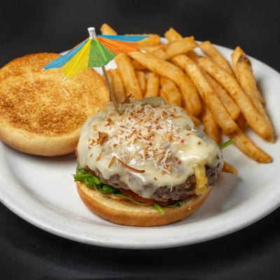Inferno Burger topped with melted cheese and an umbrella garnish, served with fries.